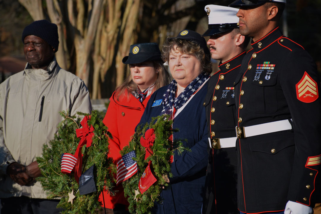 The first 'Wreaths Across America' Ceremony held in Virginia Beach, VA was conducted on December 14, 2024 at the Princess Anne Memorial Park.  Laying wreaths on the graves of military veterans were many volunteers including (shown here R to L); two unnamed Marines in dress uniform, American Legion Auxiliary Unit 110 President Tonya Jones and Secretary Alicia Baqueroalvarez and an unnamed civilian.  (Photography by Bert Wendell, Jr.)